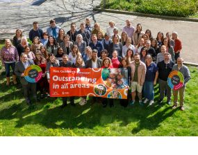 Group photo of staff and leaders from children's services with an outstanding banner